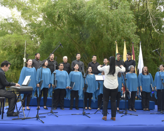 Imagen del coro de la excelencia Unibagué interpretando una canción en el polideportivo de la U todo vestidos de color azul